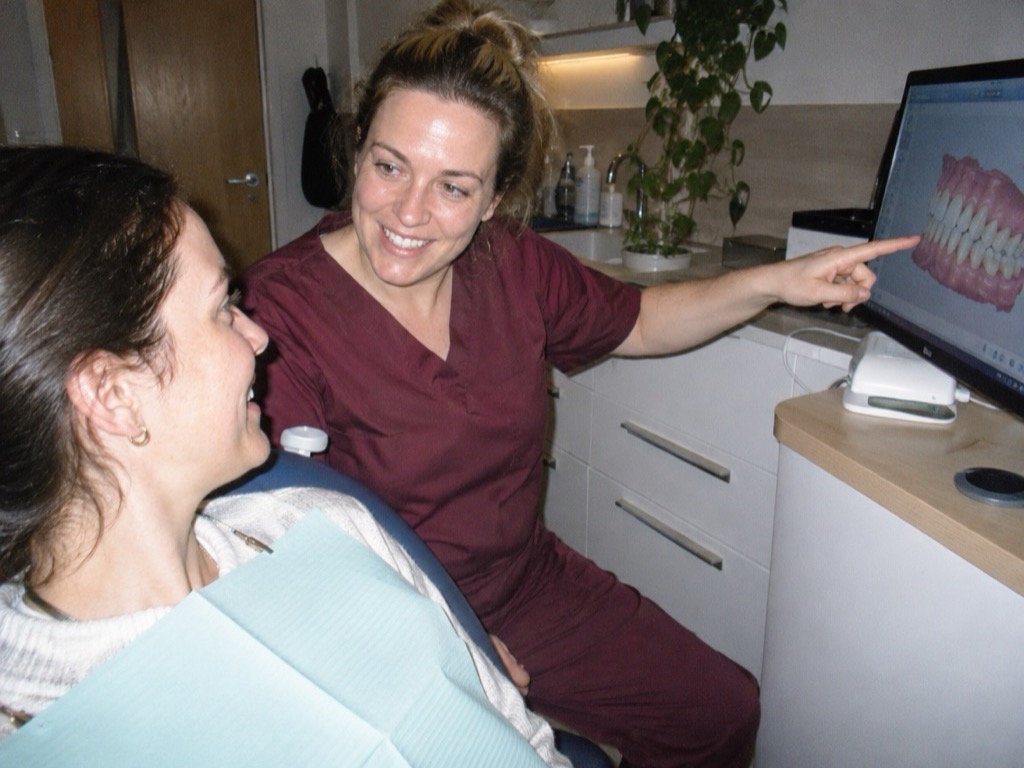 A patient looking at their own intraoral scan with the dentist
